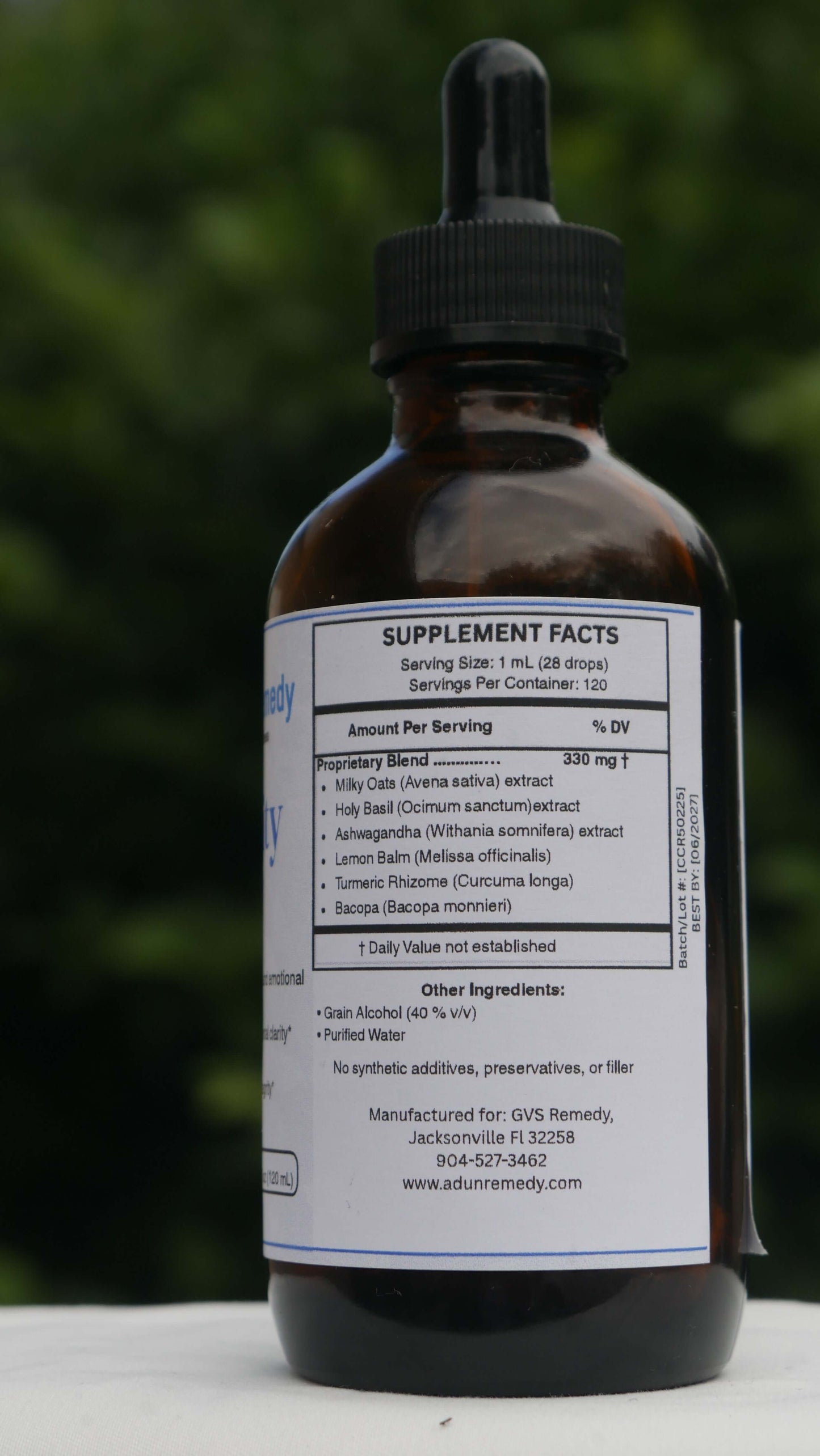 Bottle of CalmClarity Elixir with a blurred green background